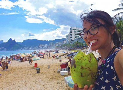 Traveller with coconut drink on Ipanema Beach, Rio de Janeiro, Brazil