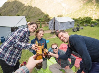 Travellers having a beer together during a night camping along the Inca Trail in Peru on an Intrepid Travel tour