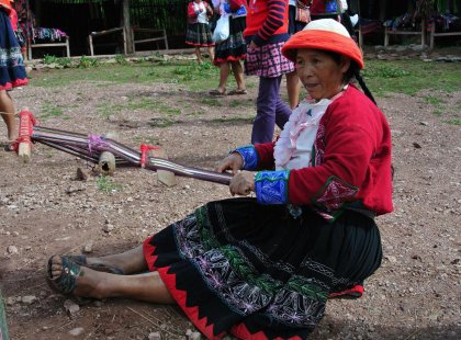 Woman pulling thread in Ollantaytambo, Peru