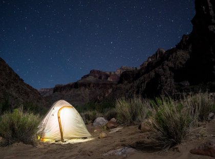 Fall asleep under a star-lit desert sky.